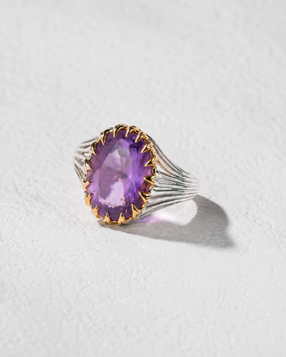 A ring with a large, purple gemstone set in a silver band.