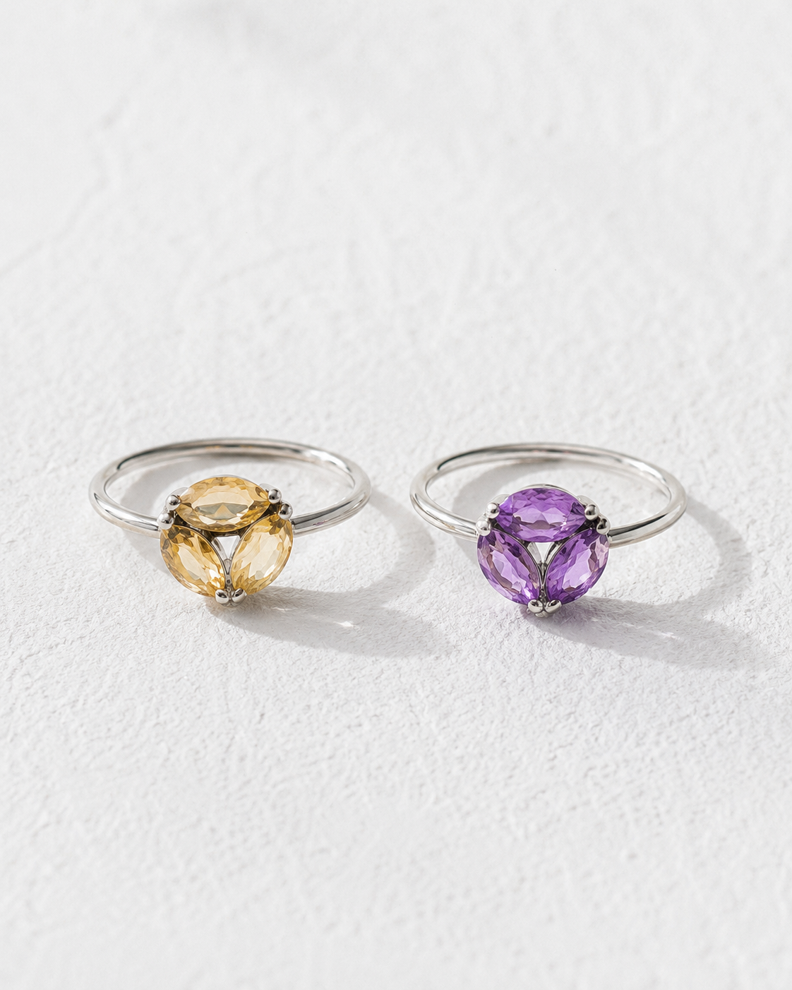 Two rings with gemstones are displayed against a white background.