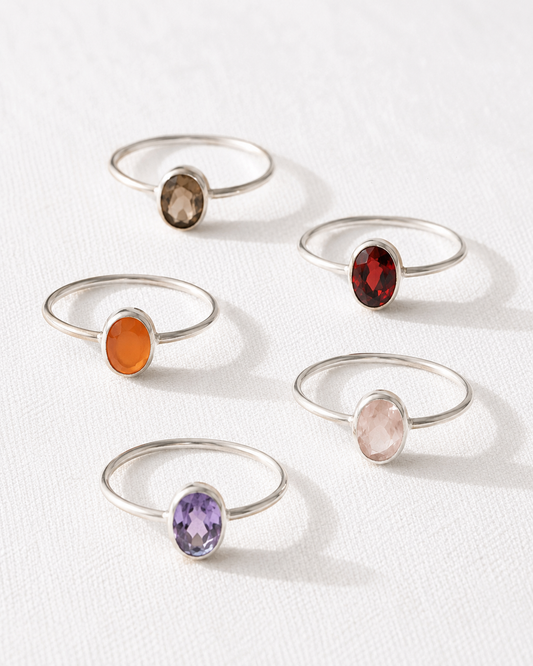 five silver rings with gemstones, each ring featuring a different colored gemstone.